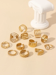 Detailed set of 12 gold plated rings featuring heart and leaf designs on beige background