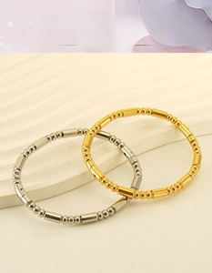 Vue détaillée des bracelets perlés en acier inoxydable or 18K et argent sur support