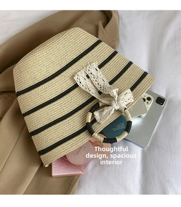 Spacious interior of beige straw tote showing storage for phone and cosmetics