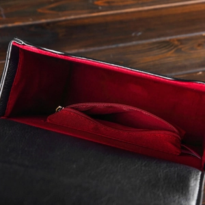 Detail view of the black leather clock bag interior with red lining and zippered pocket