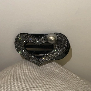 Fermaglio per capelli a cuore con strass grigi e perle su una base nera elegante
