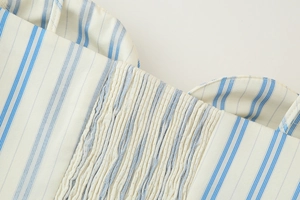 Detail of smocked elastic bodice on a blue and white striped fabric summer dress