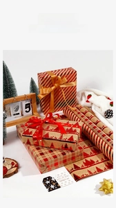 Detail of Christmas kraft wrapping paper with red reindeer, tree patterns and silk ribbons