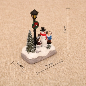 Detailed view of resin Christmas ornament with snowman and street lamp showing dimensions
