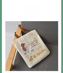 Detail of off-white canvas tote with cute chicken illustration and brown handles