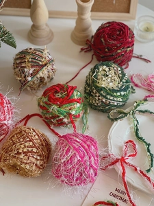 DIY Christmas yarn balls in festive red, green, and beige for holiday handicraft