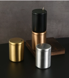 Three stainless steel toothpick holders in black, gold, and silver finishes on a table