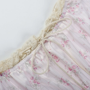 Détail macro du tissu floral rose avec bordure en dentelle beige et motif noeud coulissant