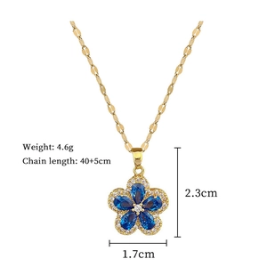 Macro shot of gold floral necklace with blue gemstone and dimensions 2.3cm by 1.7cm