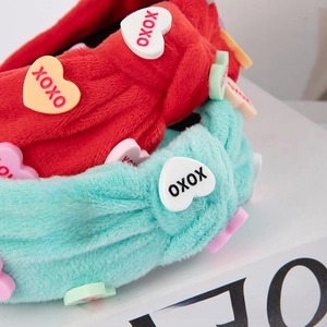 Close-up of soft plush knotted headband featuring XOXO heart resin patches details