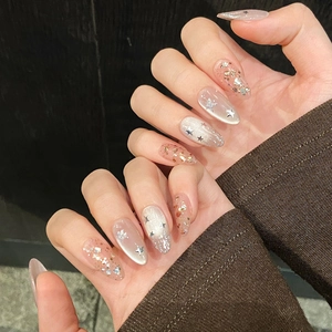 Macro detail of almond nails with cat eye effect and sparkling star sequins