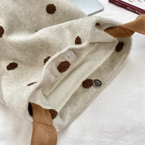 Dettaglio della borsa a secchiello in lana a pois marroni con chiusura magnetica