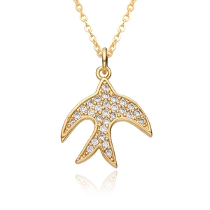 Macro detail of bird pendant with sparkling cubic zirconia on a gold-plated necklace