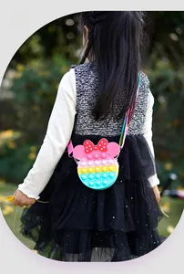 Outdoor shot of a child wearing a Minnie Mouse style colorful silicone pop-it shoulder bag