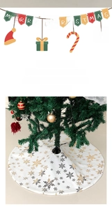 Detail of white Christmas tree skirt with gold and black snowflake patterns for holiday decor