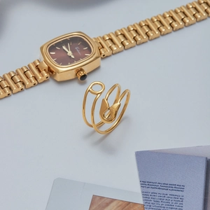 Detail of 18K gold stainless steel multi-layer ring with paperclip design on a desk