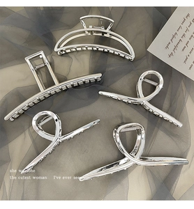 Detail view of five silver metal hair clips with geometric and twisted designs