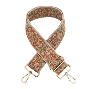 Detailed view of bohemian floral embroidered bag strap with golden metal lobster clasps
