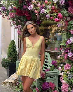 Détail de la robe mini jaune en dentelle avec col en V et finitions de dentelle délicate