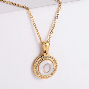 Close-up of gold letter O necklace with white mother-of-pearl and sparkling rhinestones