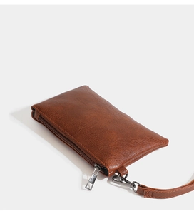 Detailed view of a brown lychee pattern PU leather wallet with zipper and wrist strap