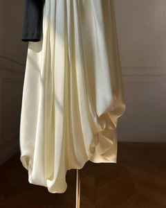 Detailed view of cream-white satin fabric texture and elegant draping on a slim-fit shirt