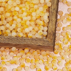 Macro view of gradient yellow and orange glass beads for DIY jewelry making and crafts