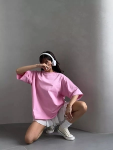 Pink oversized cotton short sleeve t-shirt paired with white pleated skirt for casual style