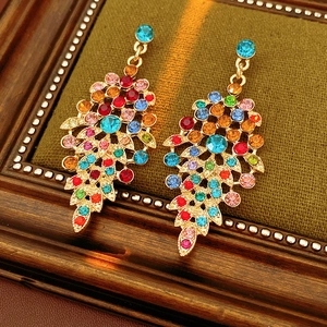 Detail of vintage gold leaf earrings with colorful rhinestones on green velvet