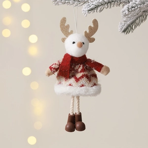 Christmas plush reindeer ornament in knit sweater hanging on snowy festive pine branch