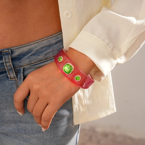 Detailed macro view of vintage pink resin bangle with green crystal embellishments