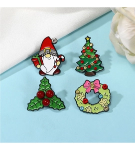 Detail view of four Christmas enamel brooches with rhinestones on light blue surface