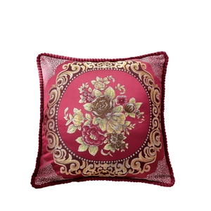 Deep red jacquard cushion with golden floral embroidery and fringed edges on white background
