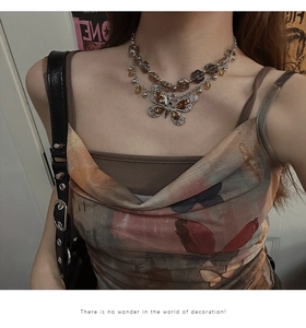 Close-up of a double-layer vintage butterfly necklace with amber beads on a model