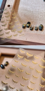 Macro detail of M-971 metallic gold liquid fringe nail stickers and finished manicure