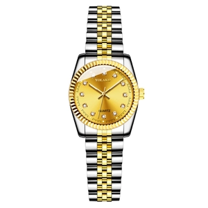 Macro shot of gold dial with diamond markers and silver-gold steel band on quartz watch