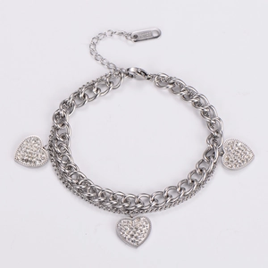 Detailed close-up of a double-layer stainless steel bracelet with three crystal heart charms