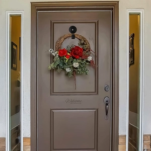 Strong black magnetic hook holding a floral wreath on a dark front door entrance