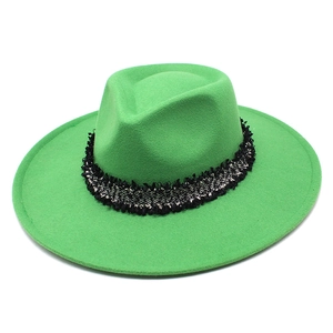 Détail d'un chapeau fedora en laine vert vif avec bande décorative en tweed bicolore