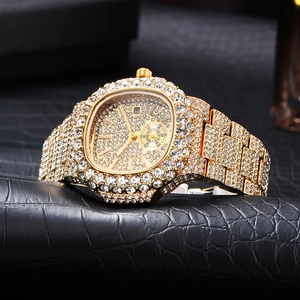 Dettaglio macro di un orologio di lusso dorato con strass e finestra del calendario