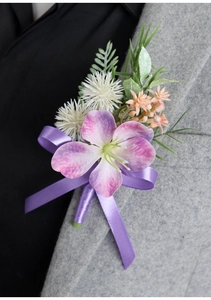 Detail of purple artificial orchid boutonniere with silk ribbon on grey suit lapel