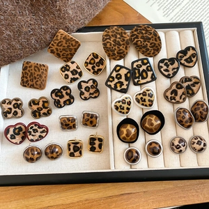 Macro shot of assorted geometric leopard print earrings with gold metal accents