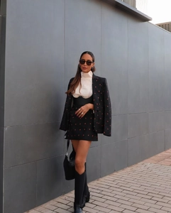 Tenue street style avec ensemble blazer à broderie fraise, mini-jupe et bottes hautes