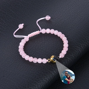 Detail of pink crystal beads bracelet showing custom photo projection on black leather background