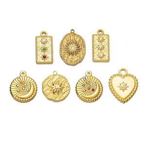 Macro detail of 7 gold-plated stainless steel charms with sun, moon and star engravings
