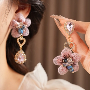 Detailed view of vintage pink embroidered flower earrings with crystals and heart drop