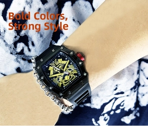 Detail of tonneau-shaped watch featuring a golden embossed dial and black rubber strap