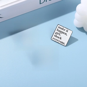 Detailed view of square enamel lapel pins with motivational quotes on a blue background