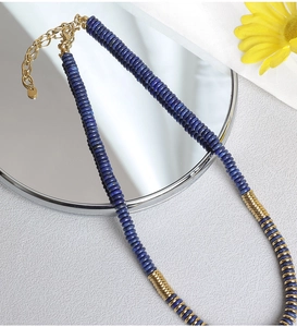 Detailed close-up of lapis lazuli beaded necklace with gold spacers and lobster clasp