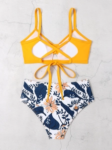 Flachbild des gelben Bikini-Tops mit überkreuztem Rücken und geblümter High-Waist-Hose
